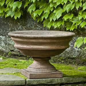 Newberry Urn on ledge against wall with green leaves