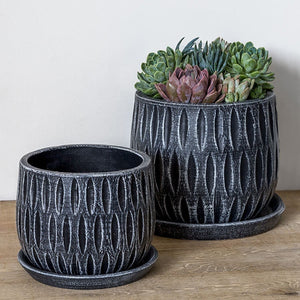 Parabola Large Round Planter - Etched Black Set of 8 filled with plants on the table