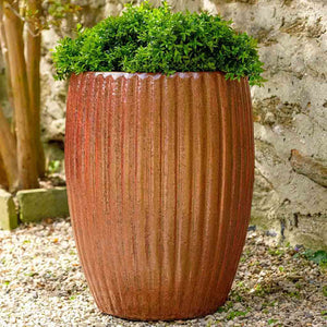 Riva Planter Volcanic Red S/2 on gravel filled with plants