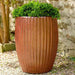 Riva Planter Volcanic Red S/2 on gravel filled with plants