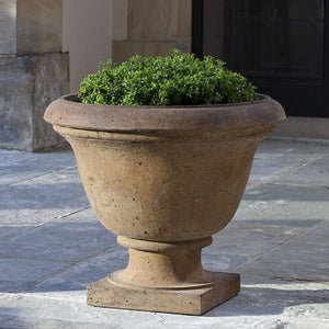 Rustic Greenwich Urn on concrete patio filled with plants
