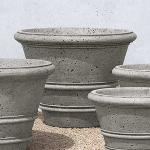 Rustic Rolled Rim 35.5 Planter on gravel beside different sizes of planters