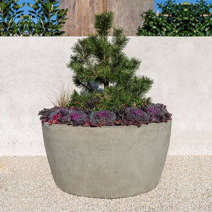Design Urb Series 2 48 inch by 24 inch planter on gravel near wall filled with plants