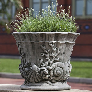 Smithsonian Chesapeake Urn Planter filled with plants in the backyard