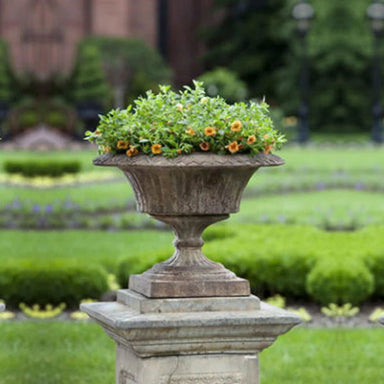 Smithsonian Fluted Valentine Urn filled with yellow flowers in the backyard