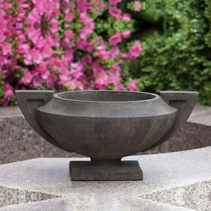 Smithsonian Grecian Urn on concrete against flower plants