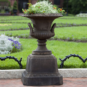 Smithsonian L’Enfant Urn on pedestal filled with flowers in the backyard
