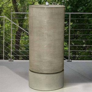 Tall Cylinder Fountain on concrete against in the fence