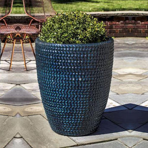 Tall Sisal Weave Planter Indigo Rain filled with plants in the backyard 