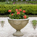 Williamsburg Neoclassic Urn filled with orange flowers in the backyard